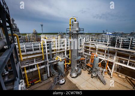 Destillationstürme (Säulen), Rohre und Rohrleitungssysteme. Ölraffinerie und Gasverarbeitungsanlage. Blauer Himmel Hintergrund. Stockfoto