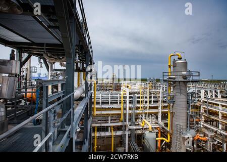 Ölraffinerie und Gasverarbeitungsanlage. Destillationstürme (Raffinierkolonnen). Rohre und Rohrleitungen und blauer Himmel auf dem Hintergrund. Stockfoto