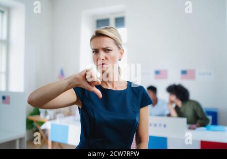 Porträt einer ernsten Wählerin mit einem Abstürzen im Wahllokal, usa-Wahlkonzept. Stockfoto