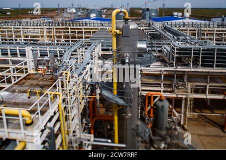 Ölraffinerie und Gasverarbeitungsanlage. Grauer Destillationsturm (Raffiniersäule). Nahaufnahme. Pipelines und Pies Hintergrund. Tilt-Shift-Effekt. Stockfoto