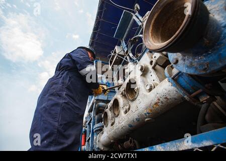 Zhaik-Munai Öllagerstätte, Kasachstan. Wartungsarbeiter, der den Motor der Schlammpumpe repariert. Baker Hughes Unternehmen.. Stockfoto