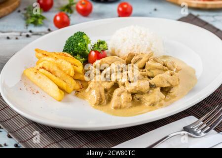 Hühnchen-Curry-Sauce. Serviert mit Reis. Natürlicher Holzhintergrund. Stockfoto