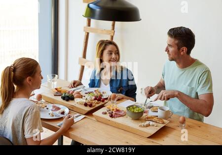 Glückliche junge Freunde beim Frühstück Stockfoto