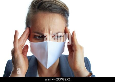 Geschäft während covid-19 Pandemie. Betonte junge Geschäftsfrau in einem grauen Anzug mit medizinischer Maske isoliert auf weiß. Stockfoto