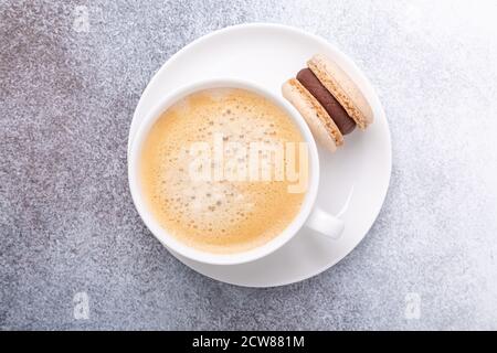 Nahaufnahme der Tasse mit Kaffee und Schokoladenmakronen auf weißem Teller. Konzept der Kaffeepause, Draufsicht - Bild Stockfoto