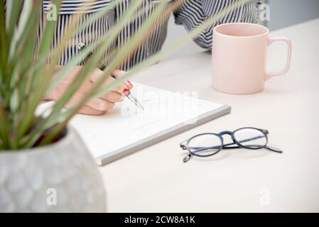 Offen Nahaufnahme Bild einer jungen Arbeiterin Notizen in häuslicher Umgebung. Stockfoto