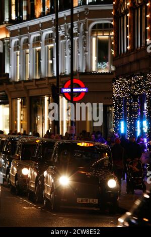 LONDON - DEC 3 : TX4 Hackney Carriage, auch London Taxi oder Black Cab genannt, Weihnachtsdekoration im Hintergrund am 3. Dec 2013 in London, UK. TX4 Stockfoto