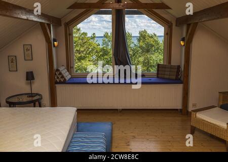 Schöne Innenansicht des oberen Stockwerks Zimmer mit großen Fenster mit Blick auf die Ostsee und blauen Himmel Hintergrund. Stockfoto