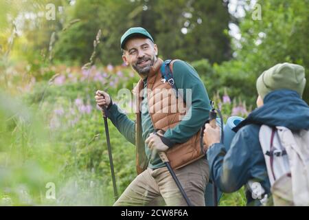 Portrait von glücklichen Vater und Sohn zusammen wandern und bergauf gehen, Fokus auf lächelnd reifen Mann mit Wanderstöcken, kopieren Raum Stockfoto