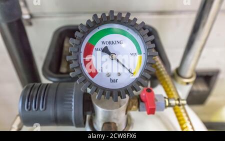 Manometer-Messgerät installiert, Messwerkzeug Ausrüstung nah oben in einer Autowerkstatt. Ventil und andere Teile im Hintergrund sind nicht im Fokus. Stockfoto