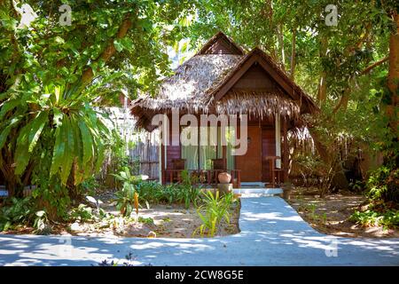 Holzbungalow an der Tür, von denen hängt ein Schild "Bitte machen Zimmer" Regenwald und Betonweg zum Haus. Stockfoto