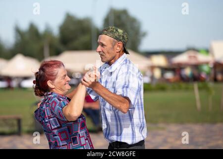 08 29 2020 Weißrussland. Ljachowitschi. Feier in der Stadt. Ältere Paar Mann und Frau tanzen. Stockfoto