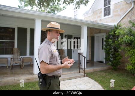 Stonewall, TX 28. August 2008: Interpretative Ranger Patrick Pelarski spricht mit Touristen außerhalb des ehemaligen US-Präsidenten Lyndon Johnsons Texas White House. Hundert Jahre nach Johnsons Geburt wurde die Familienranch am Ufer des Pedernales River für Wanderungen geöffnet. ©Bob Daemmrich Stockfoto