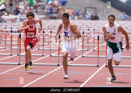 Austin, TX 10. Mai 2008: Afroamerikanische, anglo-Boys gehen in den 110 Meter hohen Hürden des Texas State UIL High School Track an der University of Texas in Austin auf die Ziellinie. ©Bob Daemmrich/ Stockfoto