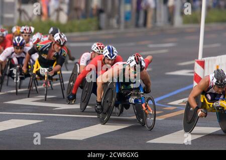 Peking, China 14. September 2008: Tag zehn des sportlichen Wettbewerbs bei den Paralympischen Spielen 2008 zeigt Männer Marathon Rollstuhlfahrer in der T54-Klasse Rollen durch die Innenstadt von Peking auf dem Weg zum Nationalstadion. Gewonnen hat der Australier Kurt Fearnley (1057) (zweiter von rechts). ©Bob Daemmrich Stockfoto