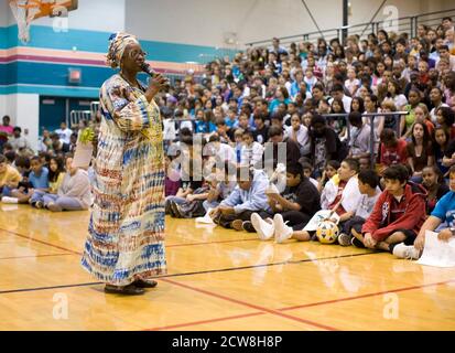 Pflugerville, TX 2. Juni 2008: Afroamerikanische Weltgeographielehrerin nigerianischer Abstammung spricht bei einer Versammlung in der Schulhalle während einer jährlichen Feier der Menschlichkeit an der Park Crest Mittelschule mit Schülern. Der "Diversity Day" umfasst ethnische Speisen, Skits, Gedichtlesungen und Musik für Schüler der sechsten bis achten Klasse. ©Bob Daemmrich Stockfoto