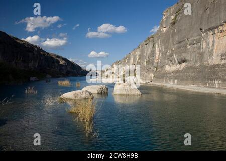 Langtry, TX 12. März 2008: Große Kalksteinbrocken säumen den Pecos River Kanal, der flussabwärts zum Rio Grande River im südlichen Val Verde County, TX, blickt. Der Fluss war eine bedeutende Nord-Süd-Barriere für Cattlemen und Frontiersmen in den frühen Tagen von Texas. ©Bob Daemmrich Stockfoto