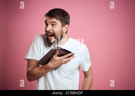 Mann wirbt eine Tablette auf einem rosa Hintergrund Codes Raum Beschnittene Ansicht der Emotionen weißes T-Shirt Modell neue Technologien Stockfoto