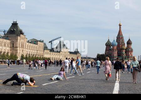 Moskau, Russland - 20. September 2020, Menschen machen Fotos auf dem Roten Platz vor dem Hintergrund der St. Basil's Cathedral. Der Mensch macht Fotos von seinem Wif Stockfoto
