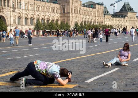 Moskau, Russland - 20. September 2020, Menschen machen Fotos auf dem Roten Platz vor dem Hintergrund der St. Basil's Cathedral. Der Mensch macht Fotos von seinem Wif Stockfoto
