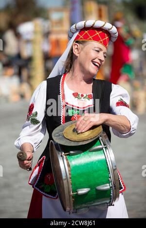 08 29 2020 Weißrussland, Ljaskowitschi. Feier in der Stadt. Ältere slawische Frau in Nationaltracht mit Trommel. Ethnische ukrainische oder weißrussische Frau Stockfoto