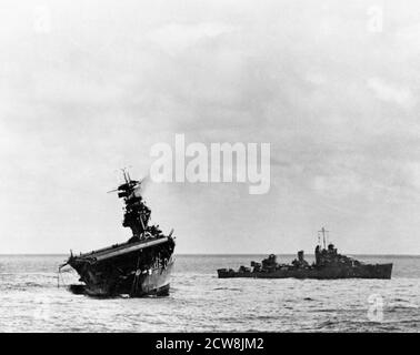 Schlacht von Midway, Juni 1942. USS Yorktown (CV-5), die von ihrer Besatzung aufgegeben wurde, nachdem sie von zwei japanischen Typ 91-Lufttorpedalen getroffen wurde, 4. Juni 1942. USS Balch (DD-363) steht rechts neben dem Hotel Stockfoto