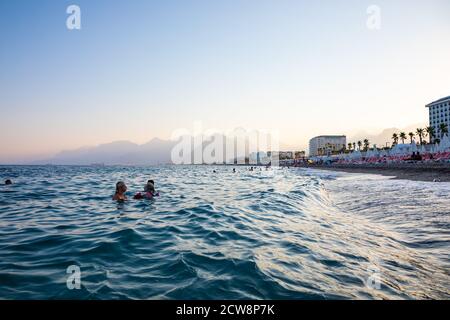 Antalya, Türkei - 2.09.2020: Konyaalti Sandstrand und Taurusgebirge im Abendlicht, Antalya, Türkei Stockfoto