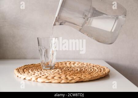 Das Gießen von Wasser aus dem Krug in ein Glas Stockfoto