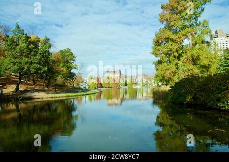 Spiegelung von Gebäuden und Bäumen auf einem See, im Herbst im Central Park, Manhattan, New York, USA Stockfoto