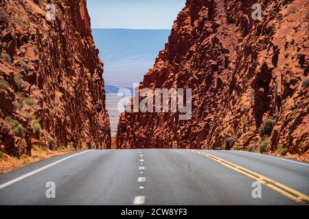 Straße gegen die hohen Felsen. Asphaltstraßen und Berge unter dem blauen Himmel. Stockfoto