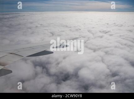 Luftaufnahme aus einem Flugzeug. Fliegen über den Wolken bei Sonnenaufgang Stockfoto