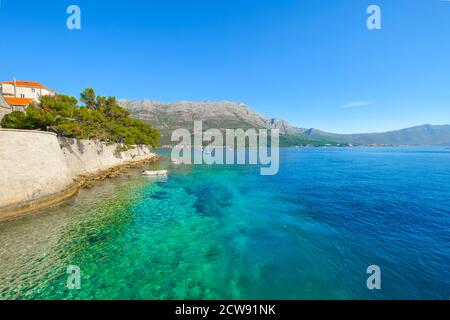 Ein kleines weisses Boot entlang der blauen grüne Küste in der Nähe von Hvar und Dubrovnik, Kroatien auf der Dalmatiens. Stockfoto