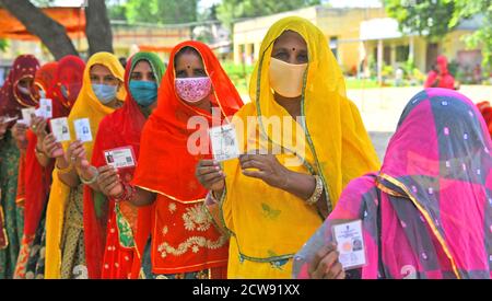 Beawar, Rajasthan, Indien, 28. September 2020: Verschleierte Frauen aus Rajasthani warten in langen Schlangen, um während der Panchayati Raj-Wahlen in einem Wahllokal während der laufenden Coronavirus-Pandemie im Dorf Sendra in der Nähe von Beawar Stimmen abzugeben. Über 83.50 Prozent der 31.95-lakh Wähler ihre Stimmen in der ersten Phase der 947 Gramm Panchayat (Dorfrat) Wahlen in 25 Bezirken im ganzen Staat. Die Richtlinien im Zusammenhang mit COVID-19 wurden bei der Wahl nicht befolgt. Die Wähler tragen Gesichtsmasken, haben aber keine soziale Distanzierung beibehalten. Kredit: Sumit Saraswat/Alamy Live Nachrichten Stockfoto