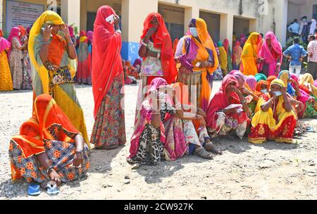 Beawar, Rajasthan, Indien, 28. September 2020: Verschleierte Frauen aus Rajasthani warten in langen Schlangen, um während der Panchayati Raj-Wahlen in einem Wahllokal Stimmen abzugeben, inmitten der laufenden Coronavirus-Pandemie im Dorf Jhala KI Chauki in der Nähe von Beawar. Über 83.50 Prozent der 31.95-lakh Wähler ihre Stimmen in der ersten Phase der 947 Gramm Panchayat (Dorfrat) Wahlen in 25 Bezirken im ganzen Staat. Die Richtlinien im Zusammenhang mit COVID-19 wurden bei der Wahl nicht befolgt. Die Wähler tragen Gesichtsmasken, haben aber keine soziale Distanzierung beibehalten. Kredit: Sumit Saraswat/Alamy Live Nachrichten Stockfoto