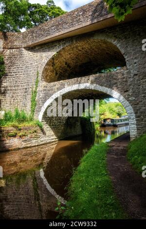 Die doppelbögige Kanalbrücke Nr. 161 bei East Marton am Leeds Liverpool Kanal mit der A59 über der Spitze, North Yorkshire, UK Stockfoto