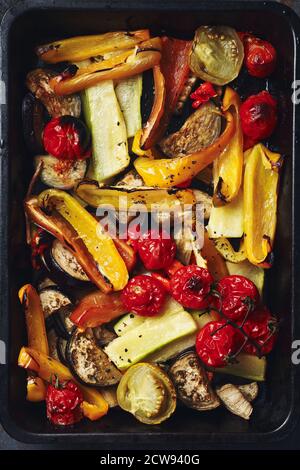 Gebratenes, geschnittenes Gemüse auf einem Backblech. Im Ofen gebackene Tomaten, Auberginen, Zucchini, Paprika. Stockfoto