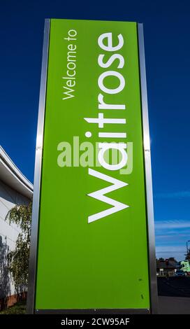 Waitrose Supermarkt Zeichen - Zeichen vor einem Waitrose Supermarkt gegen einen blauen Himmel. Stockfoto