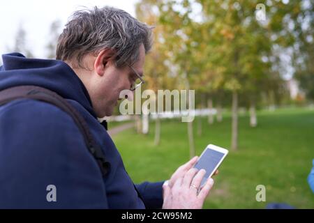 Portrait Mann verwendet ein Mobiltelefon das Konzept der Unterstützung Lernen im Alter Stockfoto