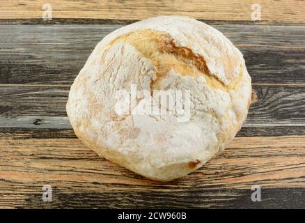 Ein kleiner runder Laib gebackenes Boule-Brot auf dem Tisch Stockfoto