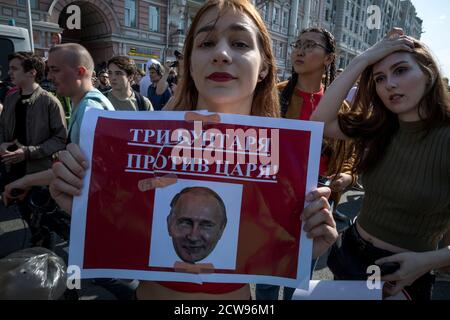 Moskau, Russland. 5. Mai 2018 Oppositionsbefürworter halten Plakate und rufen Slogans während einer nicht autorisierten Anti-Putin-Kundgebung, die von Oppositionsführer Alexei Nawalny in Moskau aufgerufen wurde, zwei Tage vor Wladimir Putins Amtseinführung für eine vierte Kreml-Amtszeit. Auf dem Banner steht: "Drei Rebellen gegen den König" Stockfoto