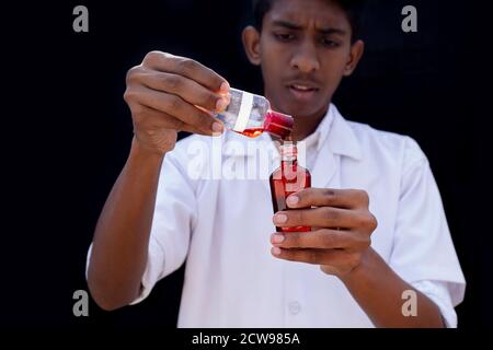Labortechniker oder Arzt hält eine Testflasche mit einer Blutprobe, Stockfoto