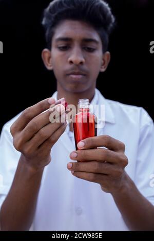 Labortechniker oder Arzt hält eine Testflasche mit einer Blutprobe, Stockfoto