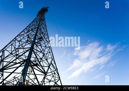 Strommasten in ländlicher Umgebung mit blauem Himmel. Stockfoto