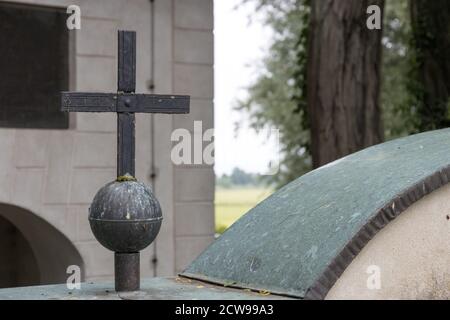 Das Kreuz aus dem metallischen Material auf dem Grabhof Stockfoto
