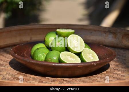 Limetten auf einem Tonteller, Frucht für ein erfrischendes Getränk Stockfoto