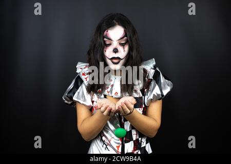 Frau in einem halloween Clown Kostüm über isolierten schwarzen Hintergrund lächelnd mit Händen Handflächen zusammen empfangen oder geben Geste. Halt und Schutz Stockfoto