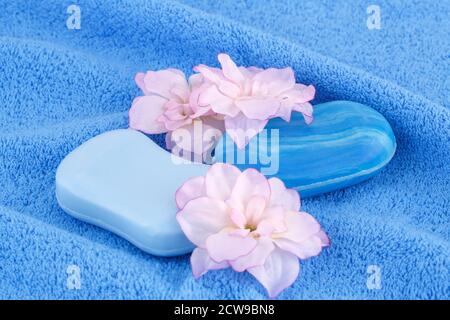 Bunte Seifen und Blumen auf blau Handtuch. Stockfoto