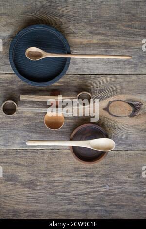 Draufsicht Holzlöffel und Teller aus edlem Holz auf Holztisch, umweltfreundliches Besteckkonzept, selektiver Fokus Stockfoto