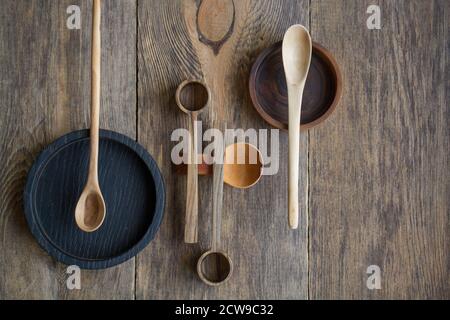 Draufsicht Holzlöffel und Teller aus edlem Holz auf Holztisch, umweltfreundliches Besteckkonzept, selektiver Fokus Stockfoto