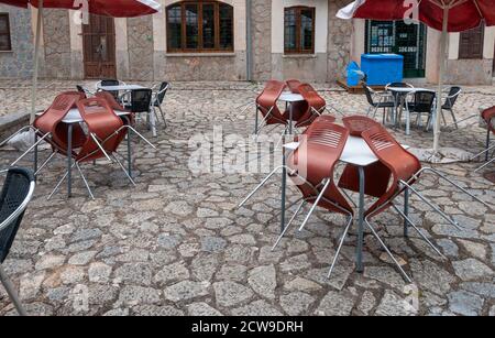 Café im Freien mit Stühlen, die vor dem Öffnen an Tischen liegen Stockfoto